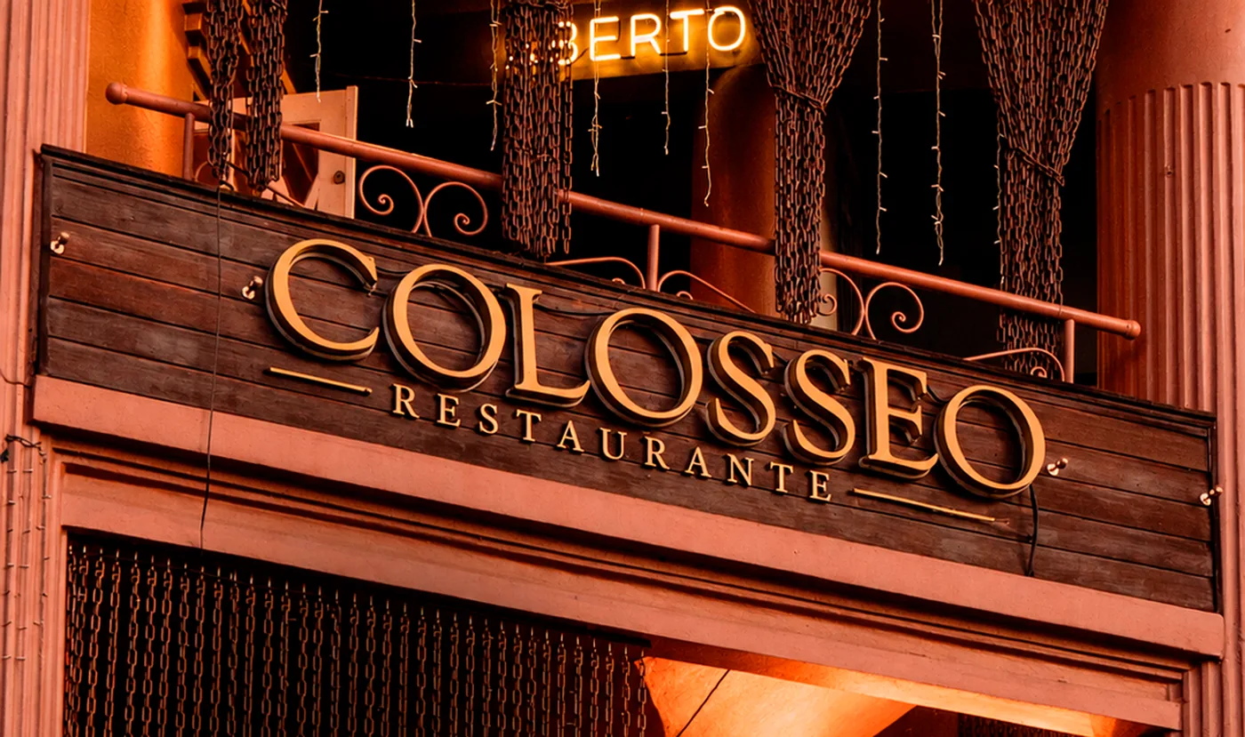 Fachada do Colosseo Restaurante com letreiro dourado iluminado